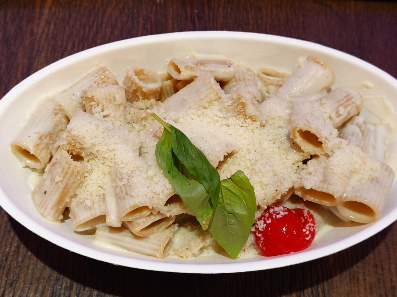 pasta topped with grated cheese and basil