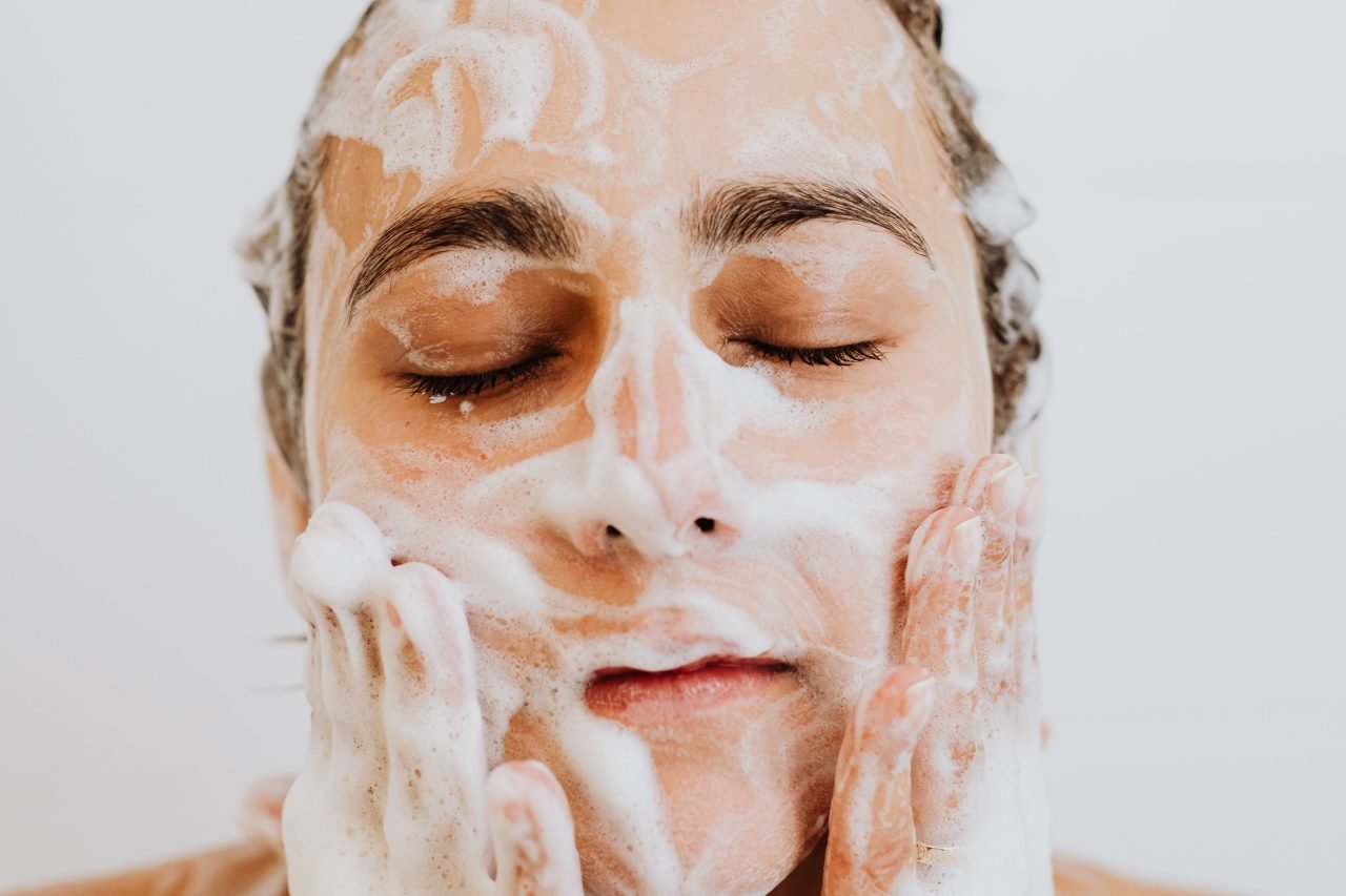washing face with tea tree face wash foam