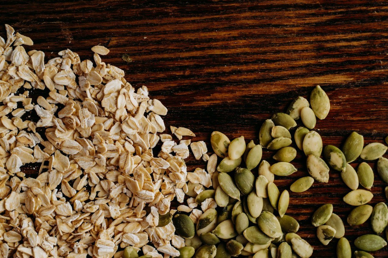 oats and pumpkin seeds arranged on a rustic wooden table