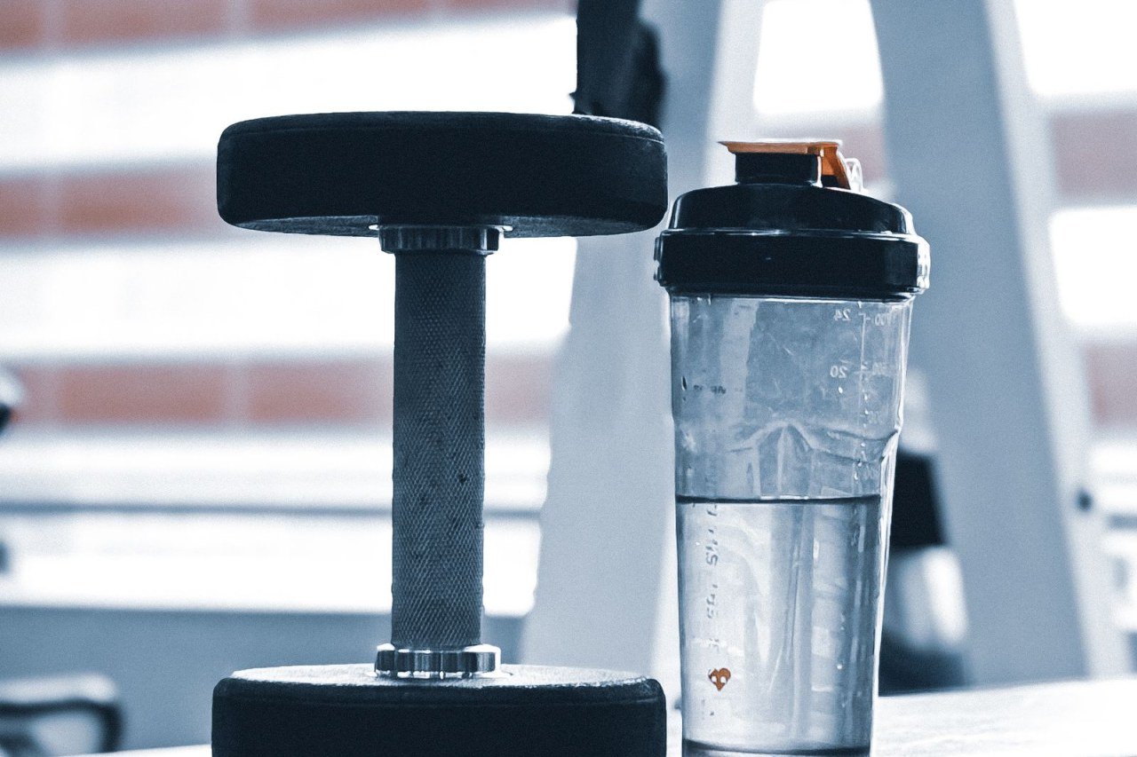 dumbbell and shaker bottle of water on a gym bench