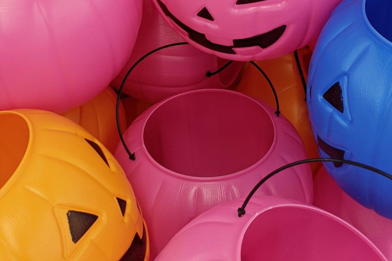 pink, orange and blue Halloween pumpkin buckets side by side