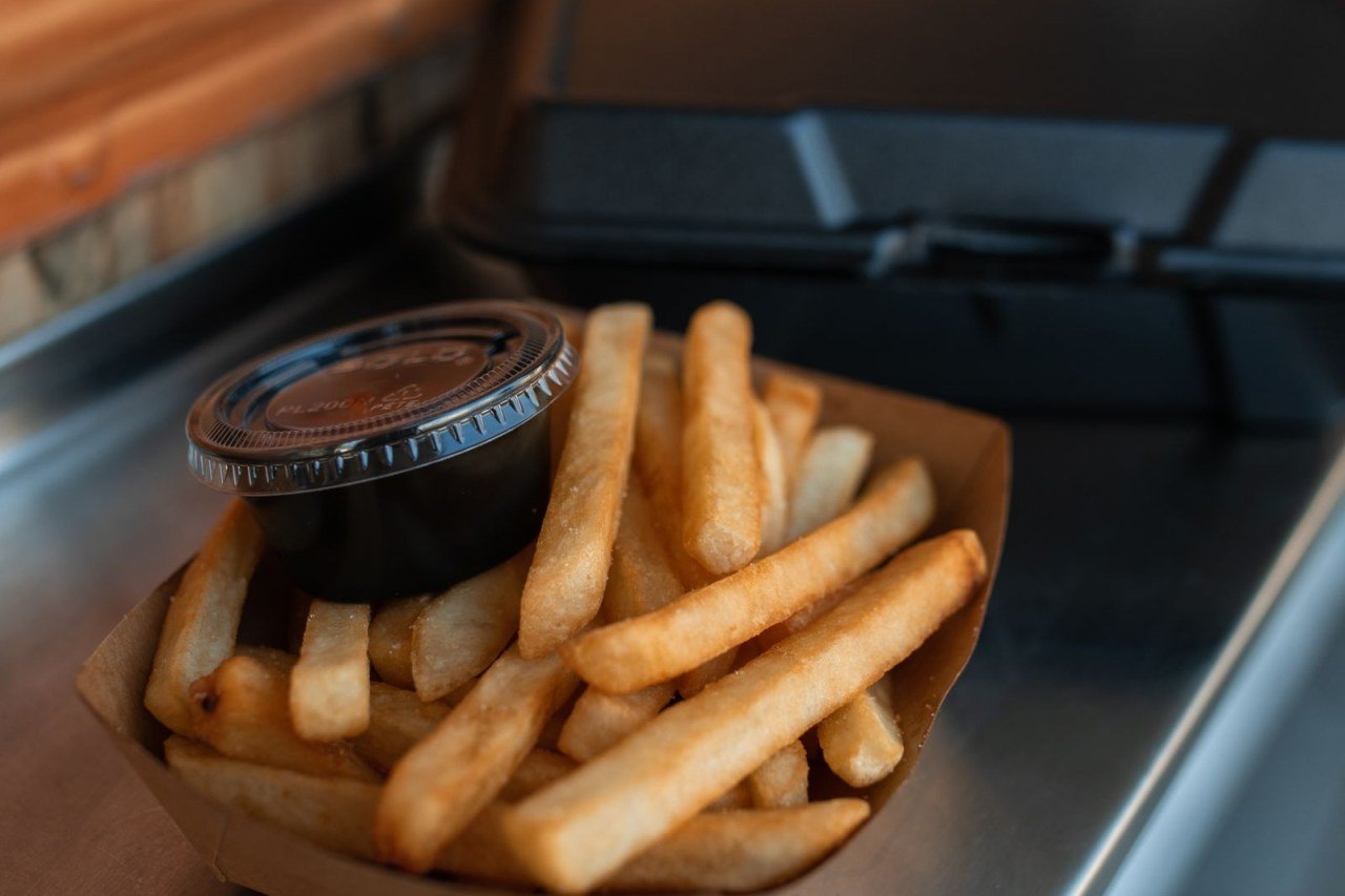 french fries in a paper carton on a tray